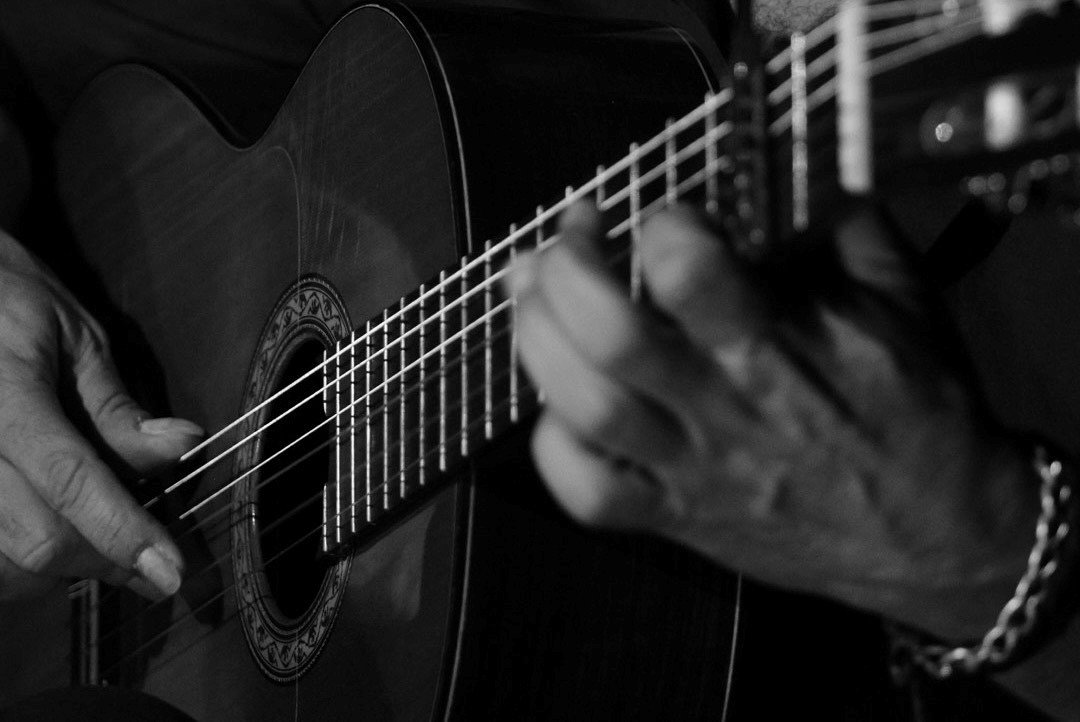 primer plano guitarrista tocando guitarra flamenca